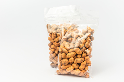 Two plastic bags with packed peanuts on a light gray background.