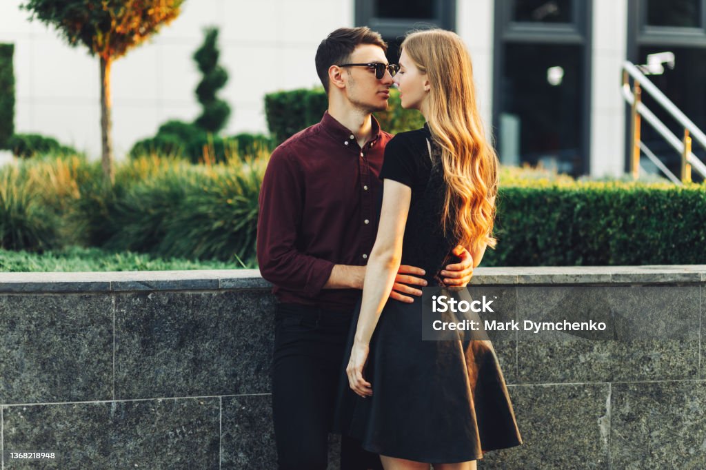 man and a woman holding hands have a pleasant time together on the eve of Valentine's Day Young romantic couple outdoors. A man and a woman holding hands have a pleasant time together on the eve of Valentine's Day. Two lovers hug and kiss on Valentine's Day. Dating Stock Photo