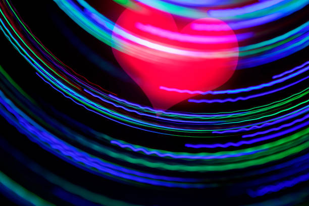 Abstract spinning glowing lines with blurred motion effect (made by fiber optics in motion). Red heart inside. Can illustrate love, romance, Valentine's day concept