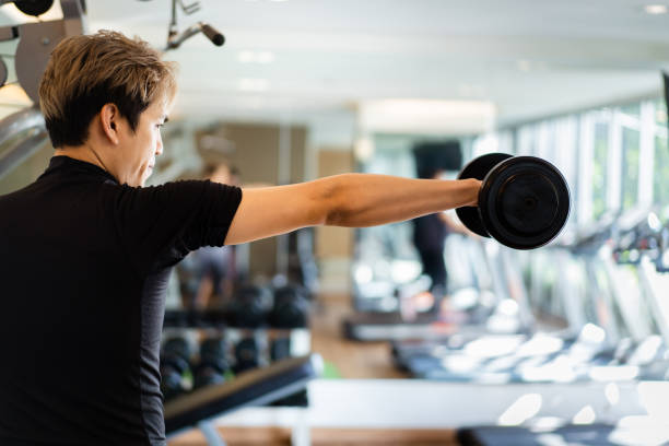 istock Man using dumbbell to practice weight exercise for body building. 1368220107