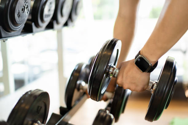 istock Man using dumbbell to practice weight exercise for body building. 1368220200