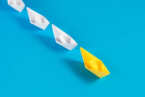 istock Yellow Paper Boat Leading Other Boats 1368220583