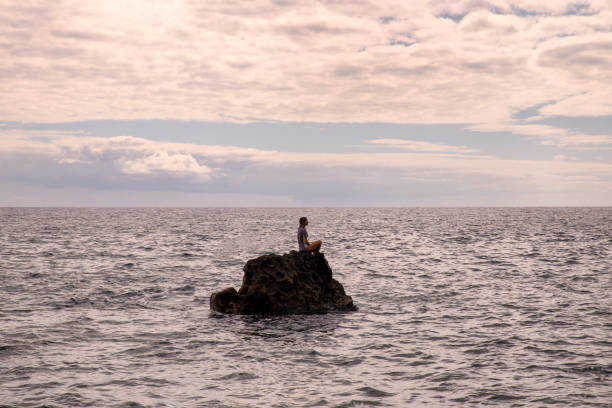 istock Girl watching sunset from the sea 1368221815