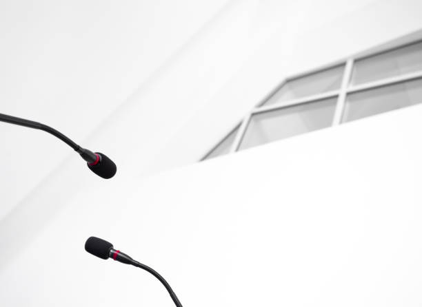 istock Press conference micro mics with a window of a modern white building in the background. 1368222622