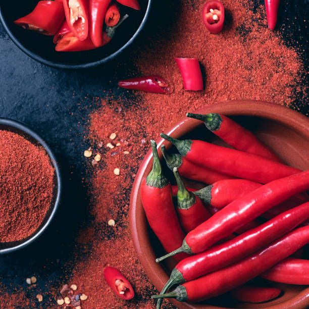 istock Red hot chili pepper background. Ground red cayenne pepper and chopped, rustic style. Spices Asian and Mexican cuisine 1368225177