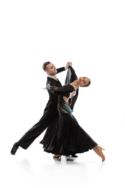 Photo of Full-length portrait of young couple practising ballroom dancing isolated over white studio background