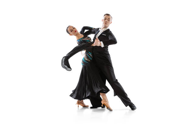 istock Artistic young couple dancing tango isolated on white studio background. Artists in black stage costumes 1368225739