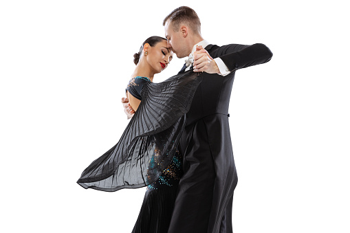 Half-length portrait of young couple performing, practising ballroom dance isolated over white studio background. Championship. Concept of art, beauty, grace, action, emotions. Copy space for ad