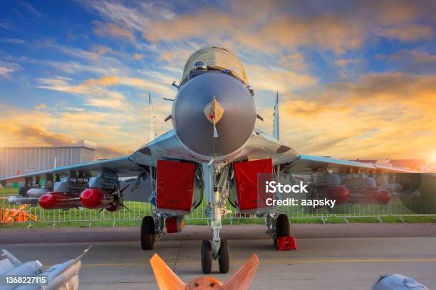 Fighter With Covered Engines And Live Ammunition On The Wings In The Parking Lot During Sunset Stock Photo - Download Image Now