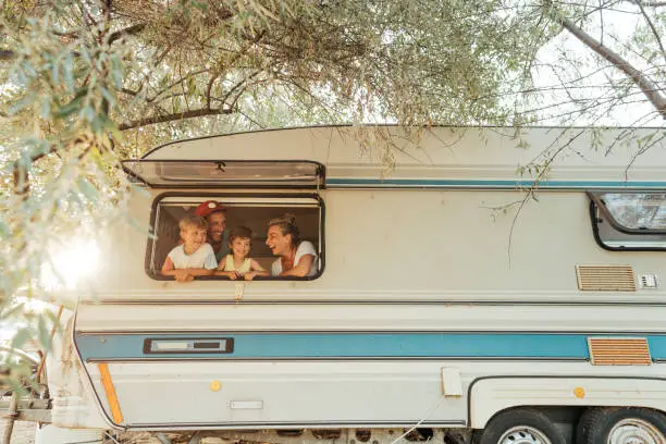 Photo of a happy family having precious moments in their camper van during their vacation