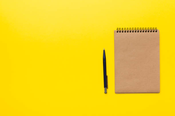istock school brown notebook on a colored background, spiral craft notepad on a table Top view 1368228901
