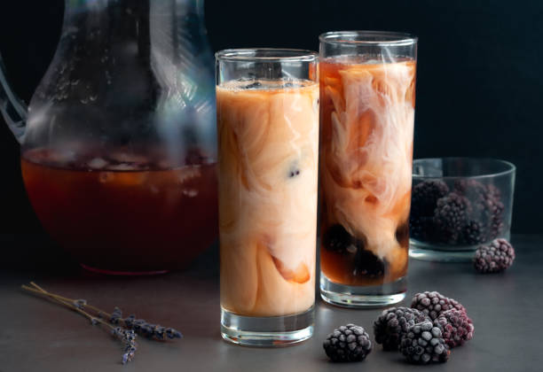 Glasses of Iced Tea Flavored with Blackberries and Cream Iced Earl Grey tea sweetened with honey and garnished with frozen blackberries tea with milk stock pictures, royalty-free photos & images