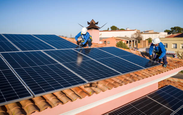 istock Male and female workers installing solar panels in a roof 1368229729