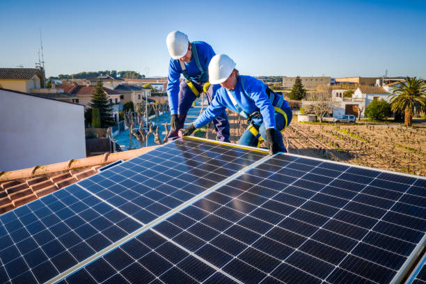 istock Male and female workers installing solar panels in a roof 1368229794
