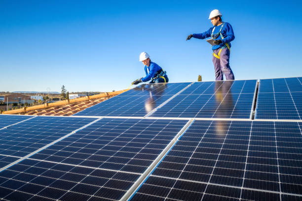 istock Male and female workers installing solar panels in a roof 1368229801