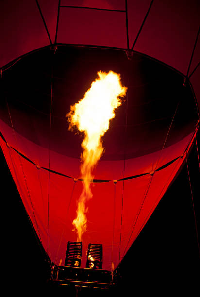 Hot air balloon is inflated in the early morning hours by a Latino man with an average age of 50 years who is the pilot in charge of providing this experience to tourists.