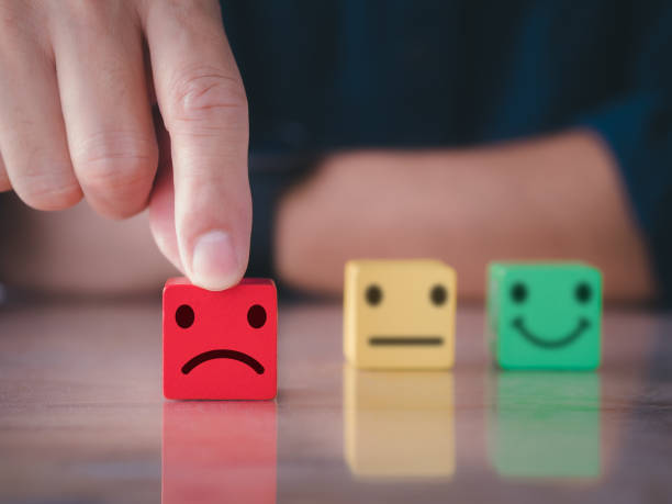 istock Customer satisfaction survey concept. Close up customer hand choose unhappy face, blurred neutral and smiley face icon on wood cube to survey feedback, rating, review, service satisfaction. 1368234478