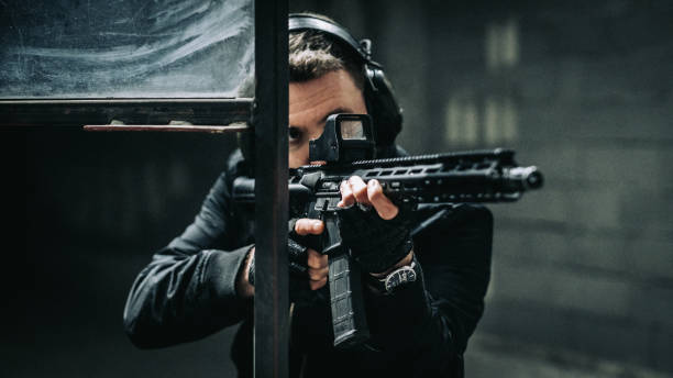 istock Man aiming M4 AR-15 rifle towards camera 1368235498