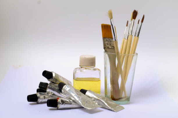 A collection of used paintbrushes in a jar, photographed in soft natural light with shallow depth of field. The image conveys a sense of creativity, artistic atmosphere, and daily life inside a working artist’s studio. Ideal for themes of inspiration, craftsmanship, and visual storytelling.