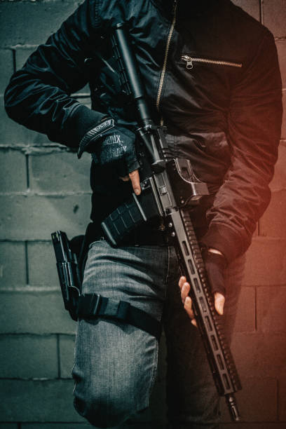istock Shooting preparations. Man holding M4 AR-15 rifle, posing to a camera. Details 1368236206
