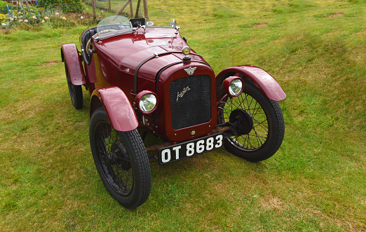 Upper Dean, Bedfordshire, England - September 07, 2019: Vintage Dark Red  1928 Austin Seven  parked on grass.