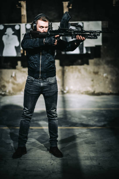 istock Shooting preparations. Man holding Bren light machine gun, target shooting 1368238940