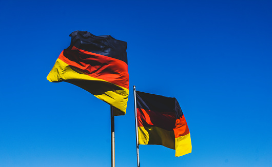 Two German flags in the blue sky.