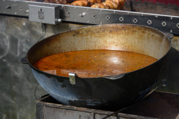 Large pan with food inside and steam over it stands on the street