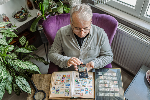 Senior Man collecting stamps from around the world