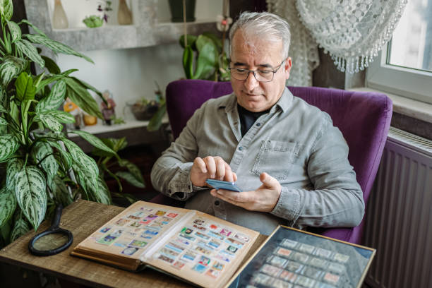 istock Senior Man collecting stamps from around the world 1368244071