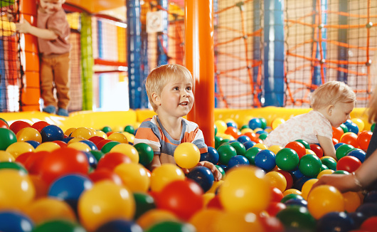Happy Children Playing in Ball Pool. Kids Having Fun in Playground Ball Pool at Amusement Centre