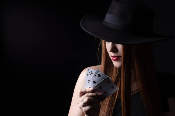 istock a girl in a hat with playing cards three sevens on a black isolate 1368246924