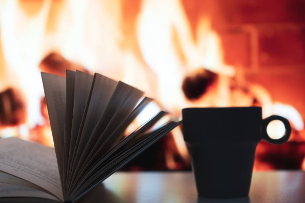 istock Open book in a cup with fireplace in the background 1368247256