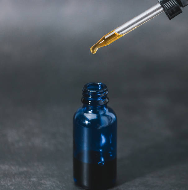 istock CBD Oil Extract Isolated Up Close Full Dropper  Into Blue Bottle 1368248512