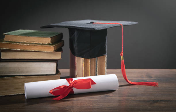 istock Graduation hat, book and diploma on the wooden table. 1368248667