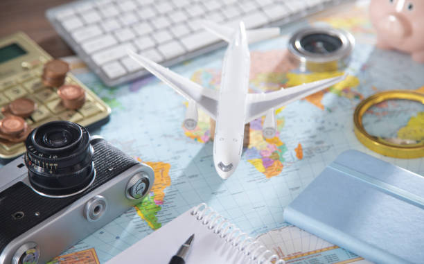 istock Calculator, coins, retro camera, airplane on the world map. 1368248675