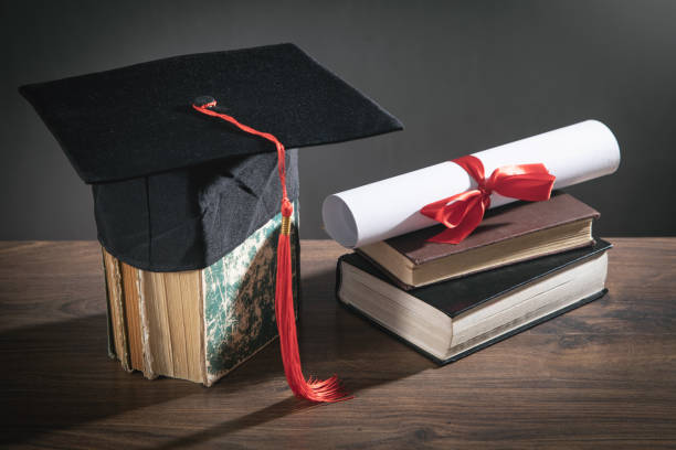 istock Graduation hat, book and diploma on the wooden table. 1368248679