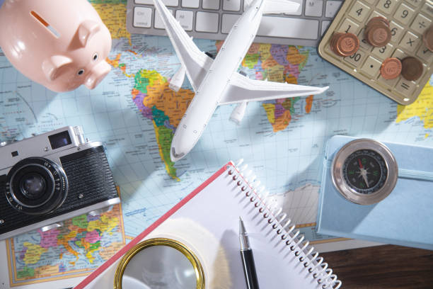 istock Calculator, coins, retro camera, airplane on the world map. 1368248692