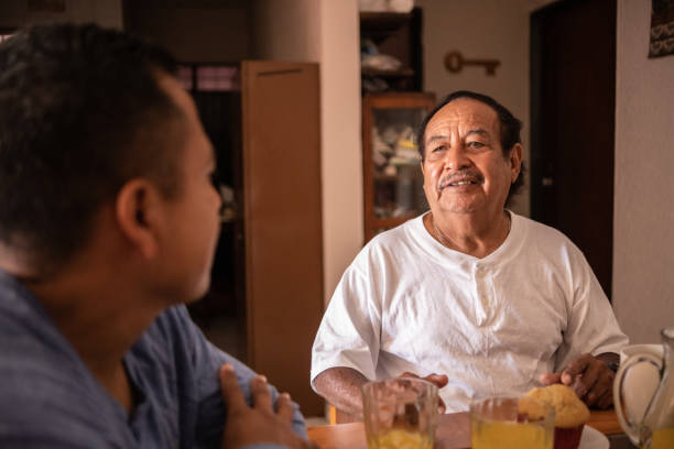 istock Latin father and son talking and eating breakfast at home 1368249847