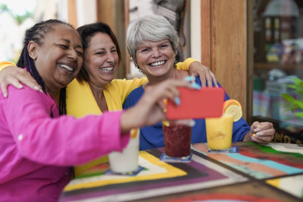 istock Multiracial senior women taking a selife using mobile phone at bar outdoor 1368249948