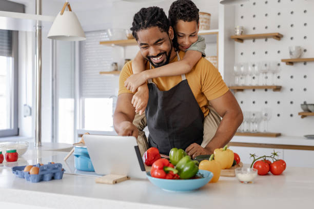 istock Young boy having fun with his father while preparing a healthy meal 1368250835