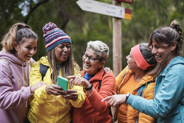 mulheres multigeracionais se divertindo juntas durante o dia de trekking no parque florestal da montanha ao usar celular - telephone nature mobile phone autumn - fotografias e filmes do acervo