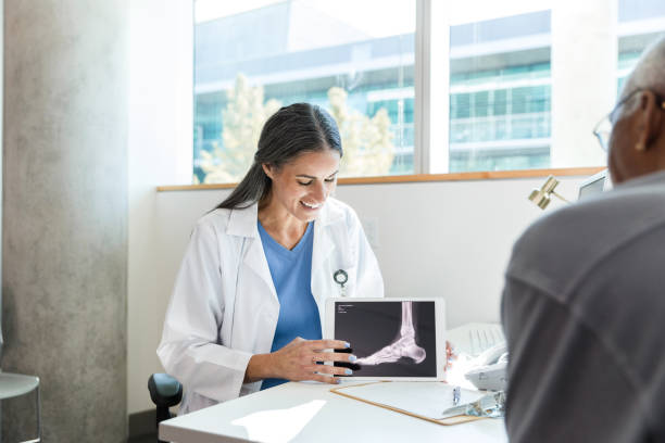 istock Female orthopedist discusses x-ray with unrecognizable senior patient 1368252350