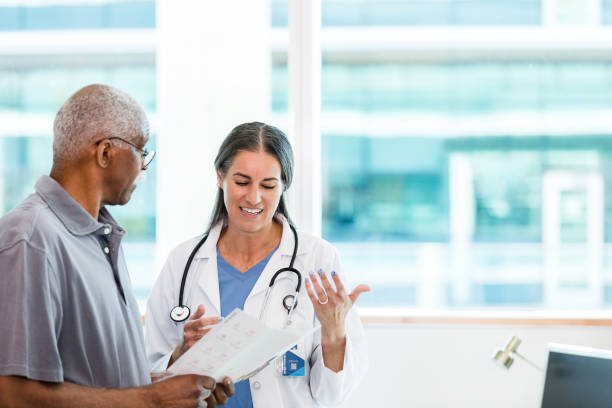istock Standing in office, doctor and patient discuss brochure 1368252358