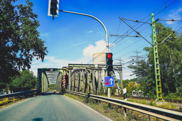 A railway bridge with a traffic light for cars.