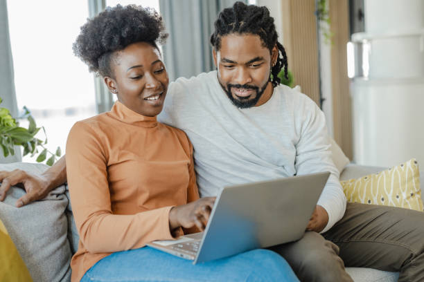 istock Young couple using laptop at home 1368252982