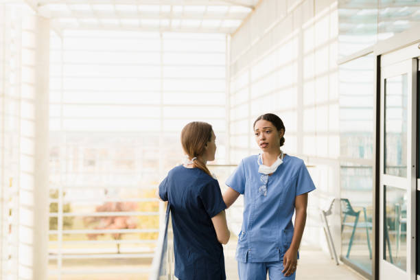 istock Distressed female nurse gets advice from friend 1368253366