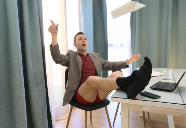 istock Happy slacker with feet on table flying a paper airplane while supposed to be working from home 1368254741