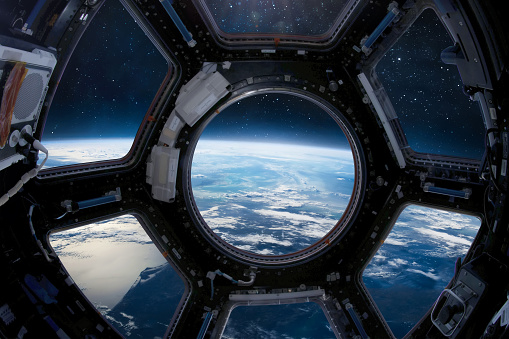 Ojo de buey de la cúpula en la estación orbital de la ISS. Estación Espacial Internacional. Órbita y espacio profundo con vista de estrellas desde ojo de buey. Nave espacial y planeta azul. Gente en sapce. Elementos de esta imagen proporcionada por la  photo