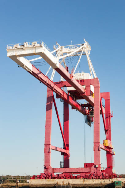 Gantry Crane Fernandina Beach, FL, USA January 21, 2018.
Red and white Gantry Crane sits idle on Commercial dock, Fernandina Beach, FL. Taken on a clear day against a blue sky. fernandina beach stock pictures, royalty-free photos & images